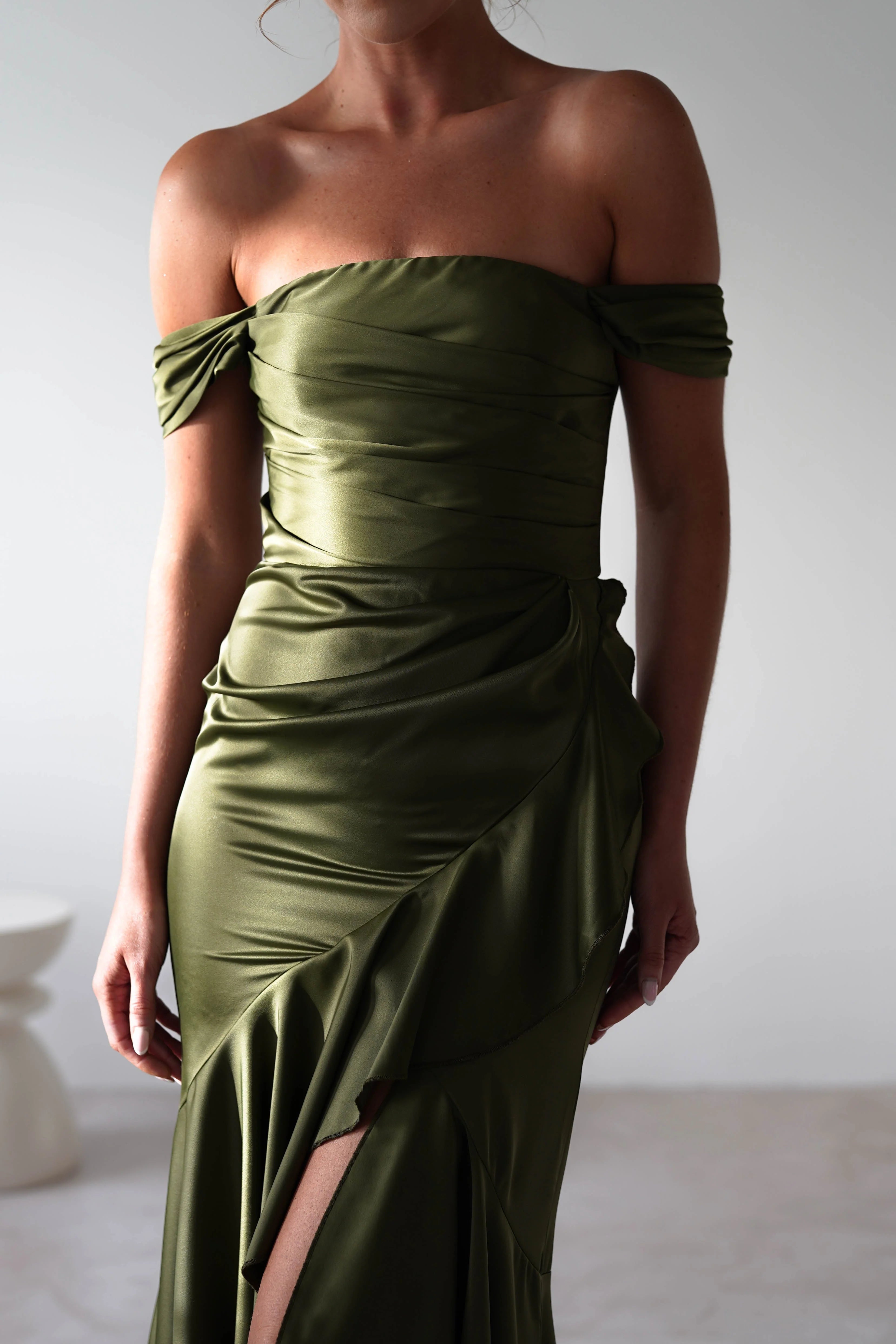 Vestido Weitese de satén verde oliva con escote en V, corpiño fruncido, falda asimétrica y dobladillo hasta el suelo.